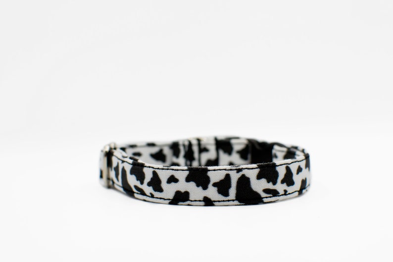 Peut inclure: Un collier de chien &agrave; imprim&eacute; vache noir et blanc avec une boucle argent&eacute;e.