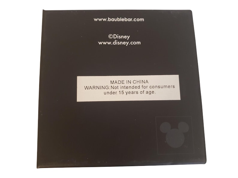 K&ouml;nnte beinhalten: Eine schwarze quadratische Box mit wei&szlig;em Text und einem Disney-Logo. Der Text enth&auml;lt Website-Adressen f&uuml;r Baublebar und Disney sowie einen Hinweis, dass das Produkt nicht f&uuml;r Verbraucher unter 15 Jahren bestimmt ist.