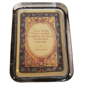 May include: A rectangular tray with a metallic gold border and a dark blue, red, and gold ornate frame design. The center features the text: AND IN THE END, IT'S NOT THE YEARS IN YOUR LIFE THAT COUNT. IT'S THE LIFE IN YOUR YEARS. ABRAHAM LINCOLN.