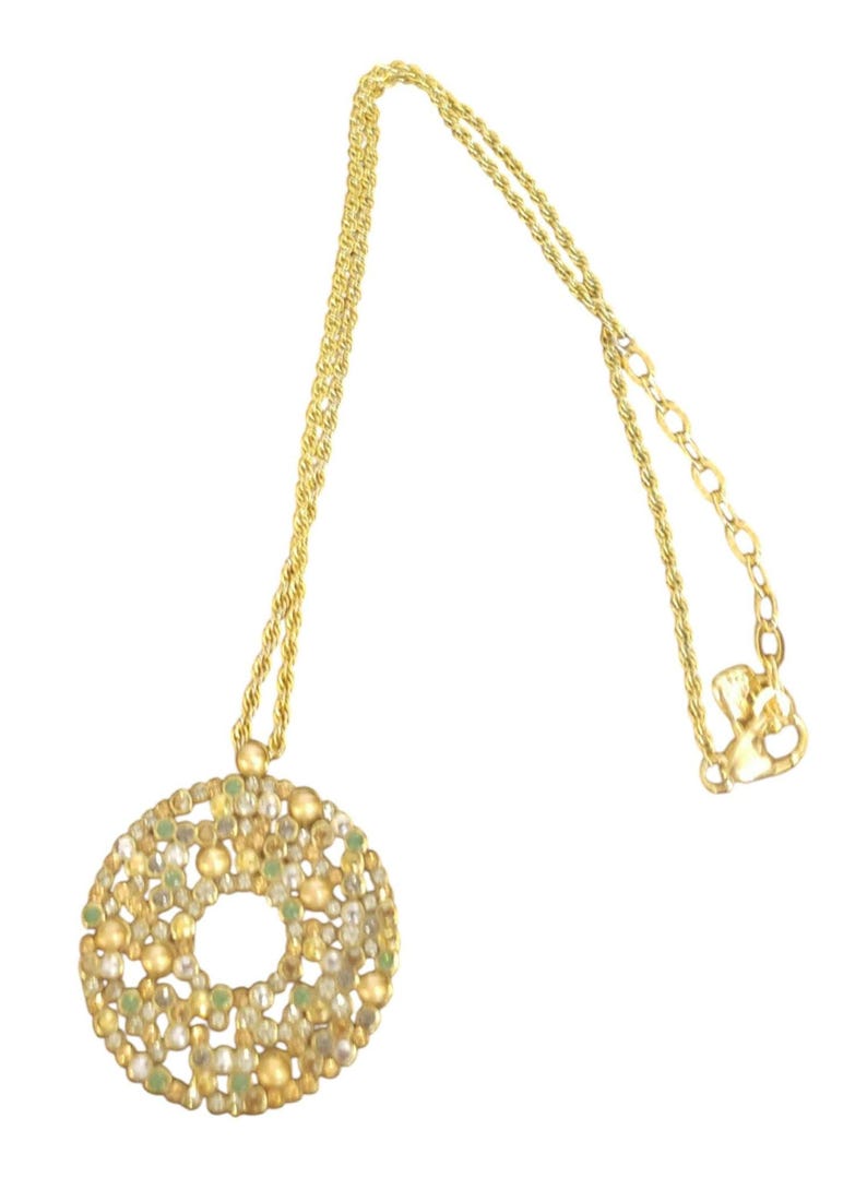 May include: A gold-coloured necklace featuring a circular pendant. The pendant is decorated with small, round beads in gold, green, and clear hues. The chain has a twisted rope design, and the clasp is visible.