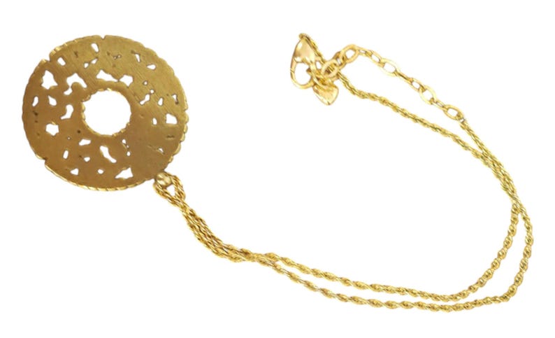 May include: A gold necklace with a circular, openwork pendant and a central hole. The pendant is attached to a fine chain. The necklace is shown against a white backdrop.