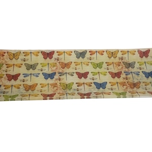 Puede incluir: Bandeja rectangular con un patrón repetido de mariposas y libélulas de colores. Los insectos son en tonos de rojo, azul, verde y naranja, sobre un fondo crema con una estética vintage.