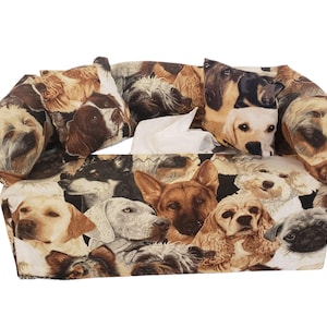 Könnte beinhalten: Ein rechteckiger Taschentuchbox-Bezug mit einem Muster aus verschiedenen Hunderassen in Braun-, Schwarz- und Weißtönen. Der Bezug hat eine Öffnung für die Taschentücher, aus der weiße Taschentücher herausragen.