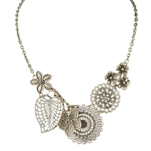 May include: Silver-toned necklace featuring floral and leaf-shaped pendants. The necklace has a delicate chain and includes detailed openwork designs. The pendants include flowers, a leaf, and circular filigree elements, creating a vintage-inspired aesthetic.