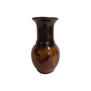 May include: A ceramic vase with a flared rim and a bulbous body. The piece features a glossy glaze with a dark brown neck that transitions into a mottled blend of deep brown, amber, and golden-tan tones across the rounded lower section.
