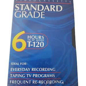 Peut inclure: Une boîte de cassette vidéo VHS Maxell Standard Grade bleue avec du texte blanc. Le devant affiche 6 HOURS IN EP MODE, T-120, et mentionne everyday recording, taping TV programs, et frequent re-recording. Le bas inclut le logo VHS et T-120/246m.