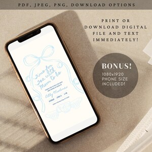 May include: A smartphone displays a light blue invitation design for a baby shower tea party. The invitation text reads "Time for Tea with Mom to be" with event details. The phone is gold-colored.