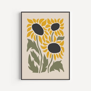 May include: A framed print featuring a stylized illustration of three sunflowers with yellow petals and black centers. The sunflowers are set against a cream background with green leaves.