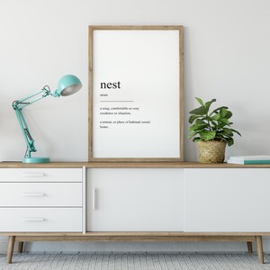 Peut inclure: Une affiche encadr&eacute;e avec le mot "nest" d&eacute;fini comme une r&eacute;sidence ou une situation confortable, douillette ou accueillante, et un lieu de retraite ou de s&eacute;jour habituel, un foyer.