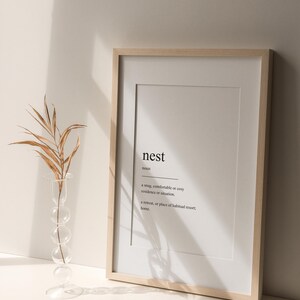 Peut inclure: Une impression encadr&eacute;e avec le mot "nest" d&eacute;fini comme une r&eacute;sidence ou une situation confortable, douillette ou agr&eacute;able, et un lieu de retraite ou de s&eacute;jour habituel ; la maison.