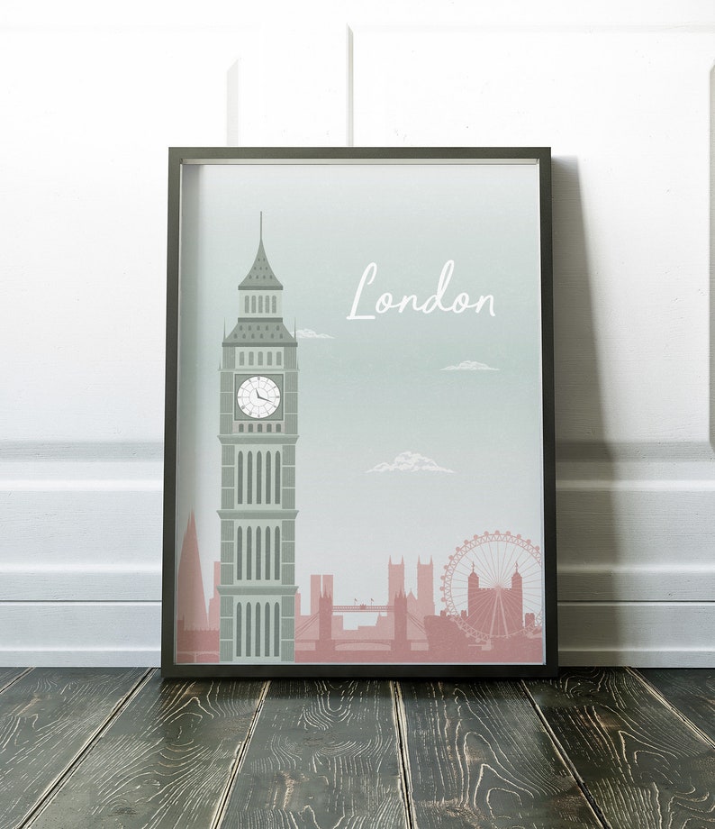 May include: Framed art print featuring a stylized illustration of London landmarks. The artwork includes Big Ben, the London Eye, and other buildings in shades of gray and pink against a light blue background. The word "London" is written in white.