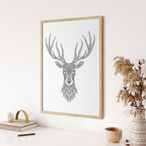 May include: A black and white line drawing of a deer's head with intricate patterns in the antlers and fur. The image is framed in a light wood frame and is hanging on a white wall.