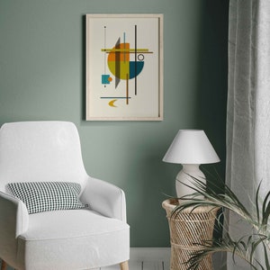 Puede incluir: Una impresi&oacute;n geom&eacute;trica abstracta enmarcada con un esquema de color amarillo, naranja, azul y verde. La impresi&oacute;n est&aacute; colgada en una pared verde salvia sobre un sill&oacute;n blanco con un coj&iacute;n a cuadros blanco y negro.