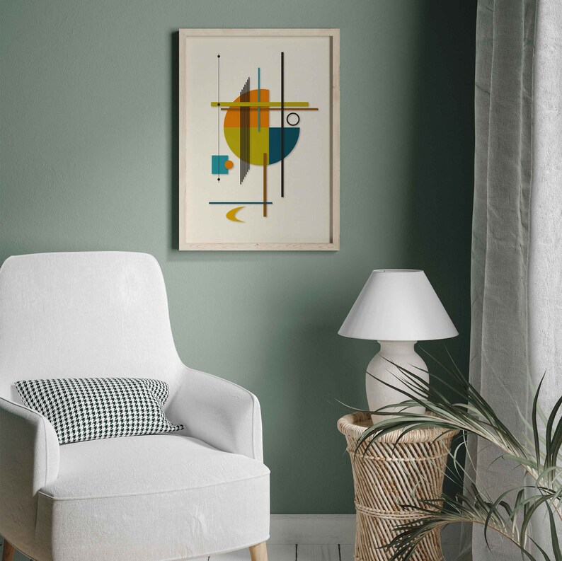 Puede incluir: Una impresi&oacute;n geom&eacute;trica abstracta enmarcada con un esquema de color amarillo, naranja, azul y verde. La impresi&oacute;n est&aacute; colgada en una pared verde salvia sobre un sill&oacute;n blanco con un coj&iacute;n a cuadros blanco y negro.