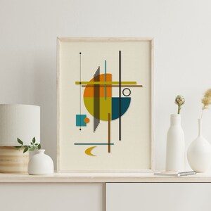 Puede incluir: Impresi&oacute;n de arte geom&eacute;trico abstracto con un c&iacute;rculo, cuadrados y l&iacute;neas en tonos de naranja, amarillo, azul verdoso y marr&oacute;n. La impresi&oacute;n est&aacute; enmarcada en un marco de madera claro y est&aacute; colgada en una pared blanca.