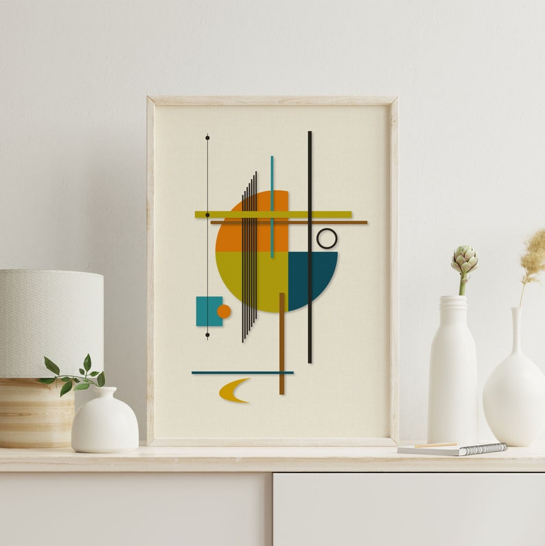 Puede incluir: Impresi&oacute;n de arte geom&eacute;trico abstracto con un c&iacute;rculo, cuadrados y l&iacute;neas en tonos de naranja, amarillo, azul verdoso y marr&oacute;n. La impresi&oacute;n est&aacute; enmarcada en un marco de madera claro y est&aacute; colgada en una pared blanca.