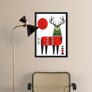 May include: A framed illustration of a stylized deer wearing a red sweater with geometric patterns. The deer is green and has large antlers. The background is white with a red circle and a green tree.