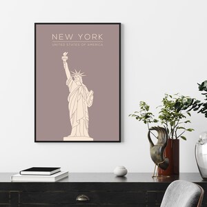 May include: A minimalist line art print of the Statue of Liberty on a light brown background. The print has the text "NEW YORK" and "UNITED STATES OF AMERICA" at the top.