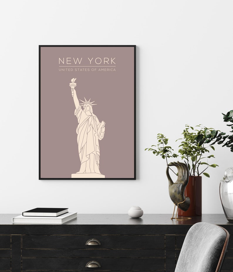 May include: A minimalist line art print of the Statue of Liberty on a light brown background. The print has the text "NEW YORK" and "UNITED STATES OF AMERICA" at the top.
