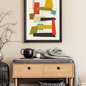 May include: A framed abstract art print with geometric shapes in red, yellow, green, blue, and black on a white background. The print is hanging on a beige wall above a wooden bench with two drawers.