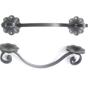 May include: Two black metal towel bars with decorative flower-shaped ends. The top bar is straight, while the bottom bar is curved.