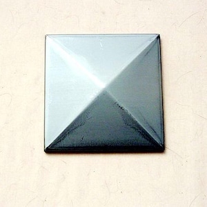May include: A square metal pyramid with a silver finish. The pyramid is slightly angled, creating a shadow effect.