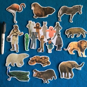 May include: A collection of animal cutouts, including a zebra, lion, elephant, hippopotamus, snake, peacock, flamingo, polar bear, walrus, and a man dressed as an explorer. The cutouts are on a blue background.