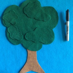 May include: A felt tree craft with a brown trunk and green leaves. The tree is made of multiple pieces of felt sewn together.
