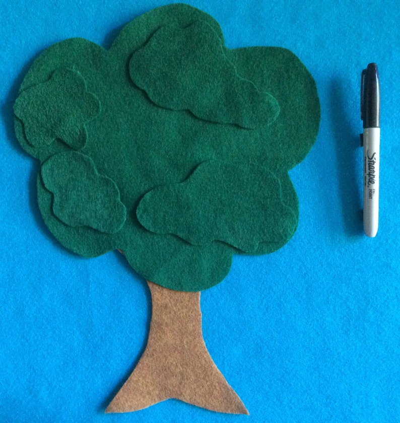 May include: A felt tree craft with a brown trunk and green leaves. The tree is made of multiple pieces of felt sewn together.