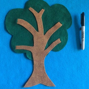 May include: A felt tree craft with a brown trunk and green leaves. The tree is cut out and ready to be used for a craft project.