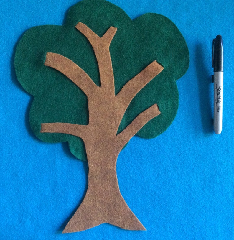 May include: A felt tree craft with a brown trunk and green leaves. The tree is cut out and ready to be used for a craft project.