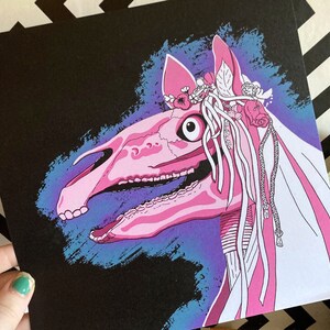May include: A pink and white skeletal horse head with a floral crown and a long white veil. The horse head is against a dark blue and purple background.
