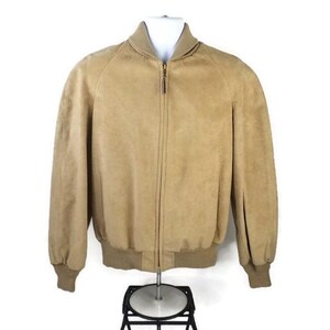 May include: A tan suede bomber jacket with a zip-up front, a ribbed collar, and ribbed cuffs. The jacket is displayed on a white mannequin against a white background. The jacket's length is approximately 26 inches.