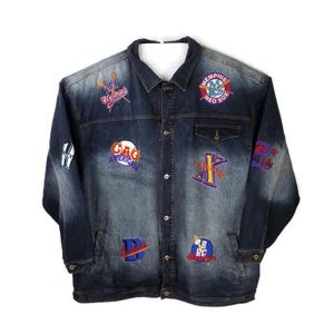 May include: Dark blue denim jacket with multiple embroidered patches. Patches include team logos and text, such as "Memphis Red Sox" and "GAG America". The jacket has a button-up front, two front pockets, and buttoned cuffs.