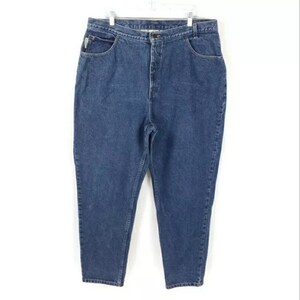 May include: A pair of blue denim jeans with a high waist and a classic five-pocket design. The jeans are hanging on a white hanger against a white background. The jeans have a straight leg cut.
