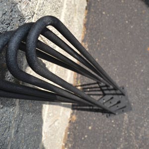 May include: Black metal hairpin legs for furniture. The legs are made of sturdy metal and have a black powder coat finish. They are designed to be used with a variety of furniture pieces, including tables, chairs, and benches.