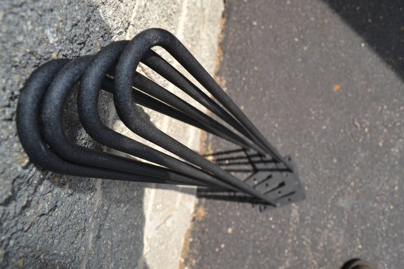 May include: Black metal hairpin legs for furniture. The legs are made of sturdy metal and have a black powder coat finish. They are designed to be used with a variety of furniture pieces, including tables, chairs, and benches.