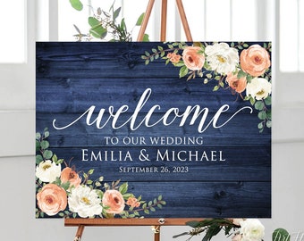 May include: A navy blue wooden sign with a floral design and the text "welcome to our wedding Emilia & Michael September 26, 2023".