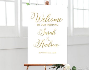 May include: White wedding welcome sign with gold lettering. The sign reads "Welcome to our wedding Sarah & Andrew September 22, 2020".