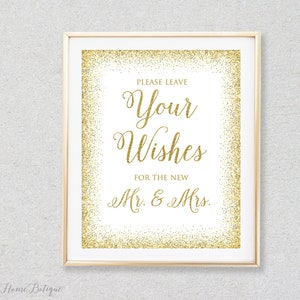 May include: Gold glitter wedding sign with the text "Please leave your wishes for the new Mr. & Mrs."