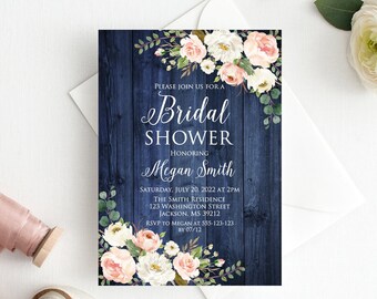 Op de afbeelding: Een blauwe houten achtergrond met witte en roze bloemen en groen. De tekst luidt "Please join us for a Bridal Shower honoring Megan Smith. Saturday, July 20, 2022 at 2pm. The Smith Residence, 123 Washington Street, Jackson, MS 39212. RSVP to Megan at 555-123-123 by 07/12."