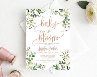 May include: A baby shower invitation with the words "baby in bloom" in elegant copper script. The invitation is decorated with watercolor greenery and includes event details. A spool of pink ribbon and a white flower are also in the image.