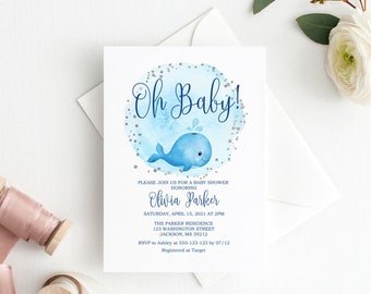 Op de afbeelding: Baby shower uitnodiging met een blauwe aquarel walvis illustratie en de tekst "Oh Baby!". De uitnodiging bevat details voor Olivia Parker's baby shower, met datum, tijd en locatie. Zilveren glitter en een witte envelop zijn ook aanwezig.