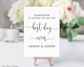 Puede incluir: Un cartel blanco con texto negro que dice "Mañana será el mejor día de todos Sarah & Jason". El cartel está en un pequeño caballete de madera.