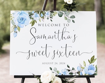 Könnte beinhalten: Ein weißes Schild auf einer schwarzen Staffelei, verziert mit blauen Blumenakzenten und Grün. Auf dem Schild steht "Willkommen zu Samanthas Sweet Sixteen" mit dem Datum 24. August 2024.
