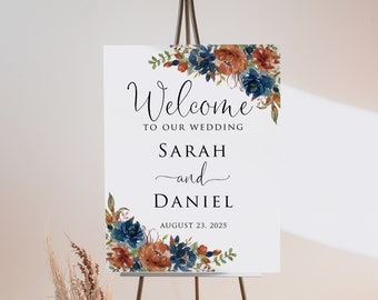 May include: Welcome sign with a floral design in shades of blue, orange, and green. The sign reads "Welcome to our wedding Sarah and Daniel August 23, 2025".