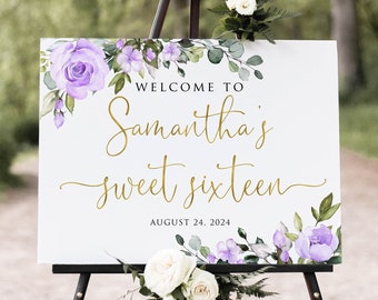 May include: A white sign on a black easel, decorated with purple flowers and greenery. The sign reads "WELCOME TO Samantha's sweet sixteen AUGUST 24, 2024" in gold script. White roses and greenery are at the base.