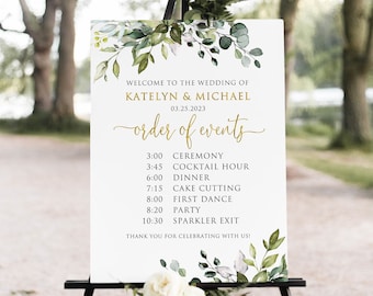 May include: A white wedding sign with green foliage and gold lettering. The sign lists the order of events for a wedding on March 25, 2023, including the ceremony, cocktail hour, dinner, cake cutting, first dance, party, and sparkler exit.