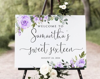 May include: Welcome to Samantha's Sweet Sixteen sign with purple flowers and greenery. The sign is on a black easel and says "Welcome to Samantha's Sweet Sixteen" with the date "August 24, 2024" underneath.