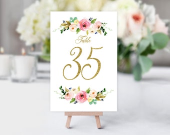 May include: White table number card with gold floral accents and the text "Table 35" in gold script.